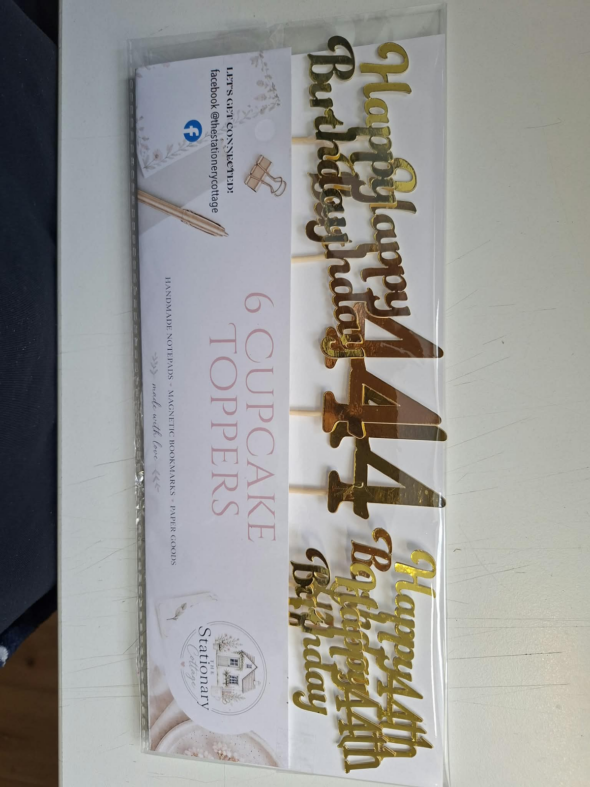 Six single-sided gold card birthday cupcake toppers packaged with a branded backing card; example made for a 44th birthday